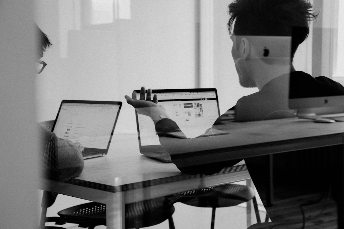 Cross-functional team collaborating on compliance workflow design at a shared workspace table